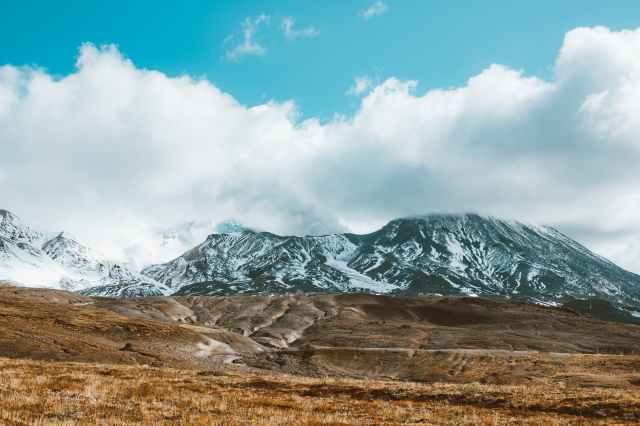 scenic snowy mountains with peaks hiding in fluffy clouds